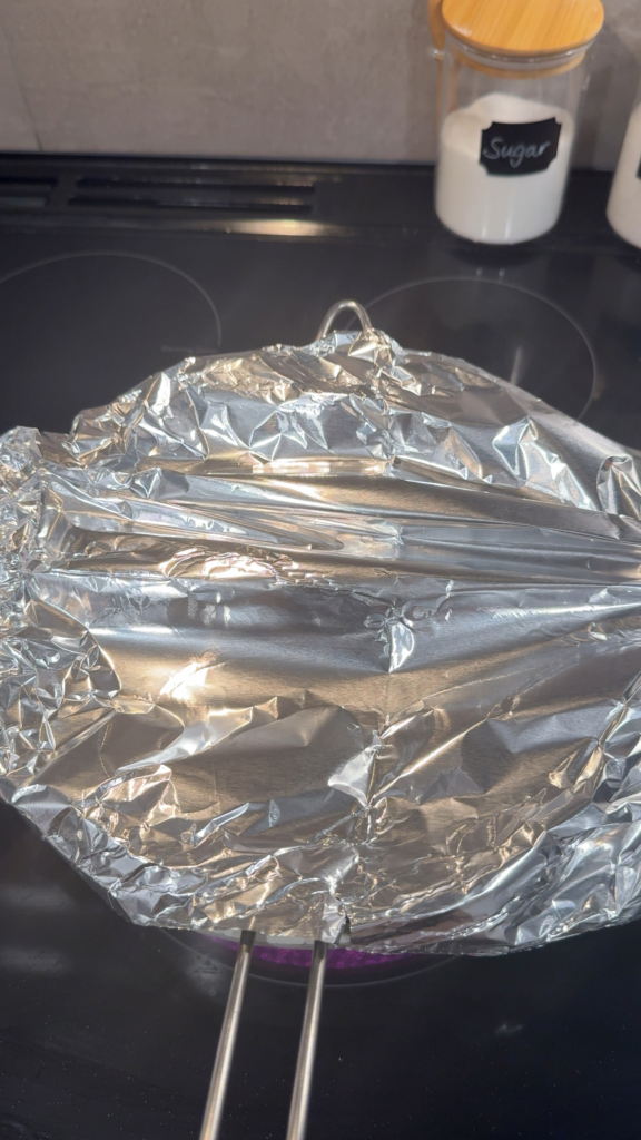 Aluminum foil covering Sticky Rice in Mesh Sieve Over a Pot of Water
