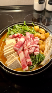 Homemade malatang with beef, bok choy, tofu, fish balls, mushrooms, and noodles in a nabe hot pot bowl