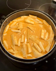 Rose tteokbokki in skillet with fish cakes