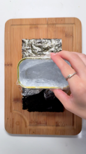 Lining a clean Spam can with plastic wrap to create a homemade musubi mold for the crispy spam musubi recipe