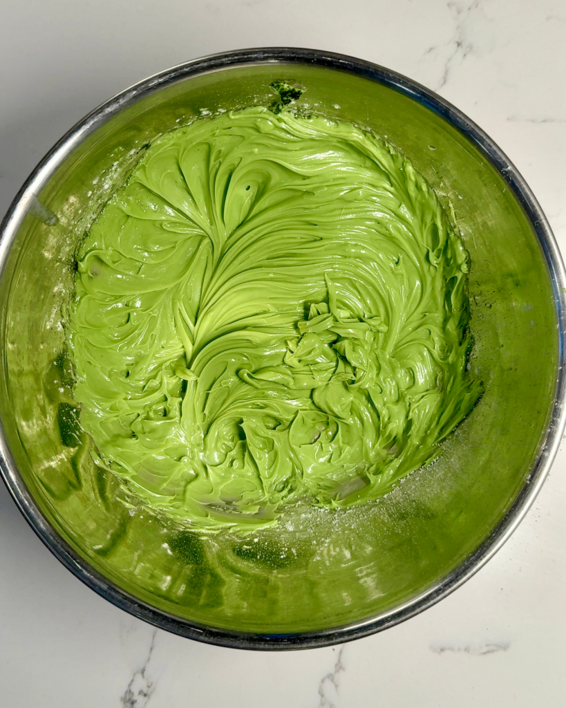 Fluffy whipped matcha butter in a bowl with a smooth pale green texture.